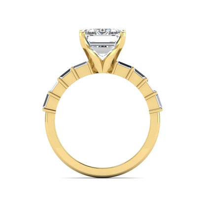 Emerald cut lab grown diamond engagement ring with baguette side diamonds in a four-prong solitaire accent setting and yellow gold tone band.