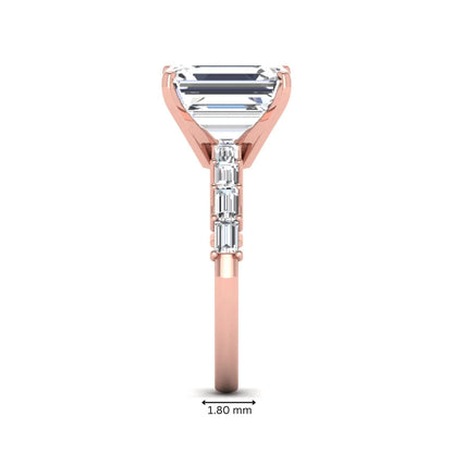 Emerald cut lab grown diamond engagement ring with baguette side diamonds in a four-prong solitaire accent setting and rose gold tone band.