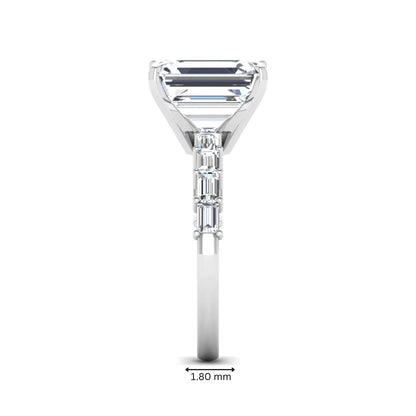 Emerald cut lab grown diamond engagement ring with baguette side diamonds in a four-prong solitaire accent setting and white gold tone band.