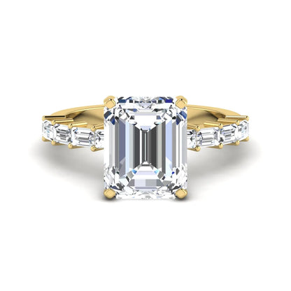 Emerald cut lab grown diamond engagement ring with baguette side diamonds in a four-prong solitaire accent setting and yellow gold tone band.