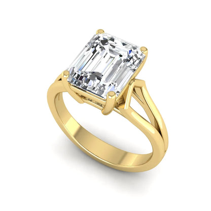 Emerald cut lab grown diamond solitaire engagement ring featuring a four-prong cathedral setting with sculpted split cathedral shoulders in a yellow gold finish.