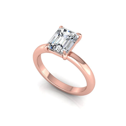 Emerald cut lab grown diamond solitaire engagement ring featuring an IGI certified center diamond in a classic four-prong setting with a polished band in rose gold