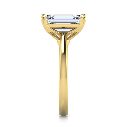 Emerald cut lab grown diamond engagement ring featuring a 3.01 carat IGI certified center diamond in a four-prong solitaire setting with hidden round diamond accents beneath the gallery and a polished yellow gold band.