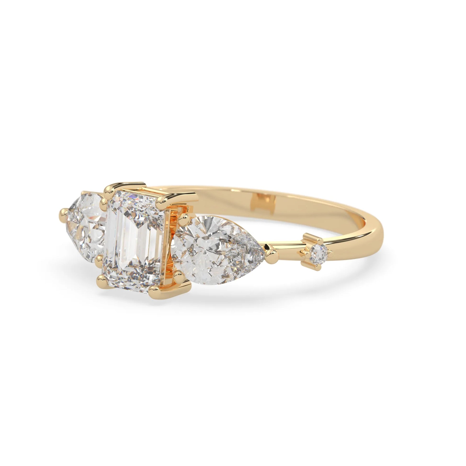 Emerald cut lab grown diamond engagement ring with pear and round diamond three stone design in yellow gold