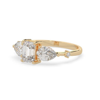 Emerald cut lab grown diamond engagement ring with pear and round diamond three stone design in yellow gold