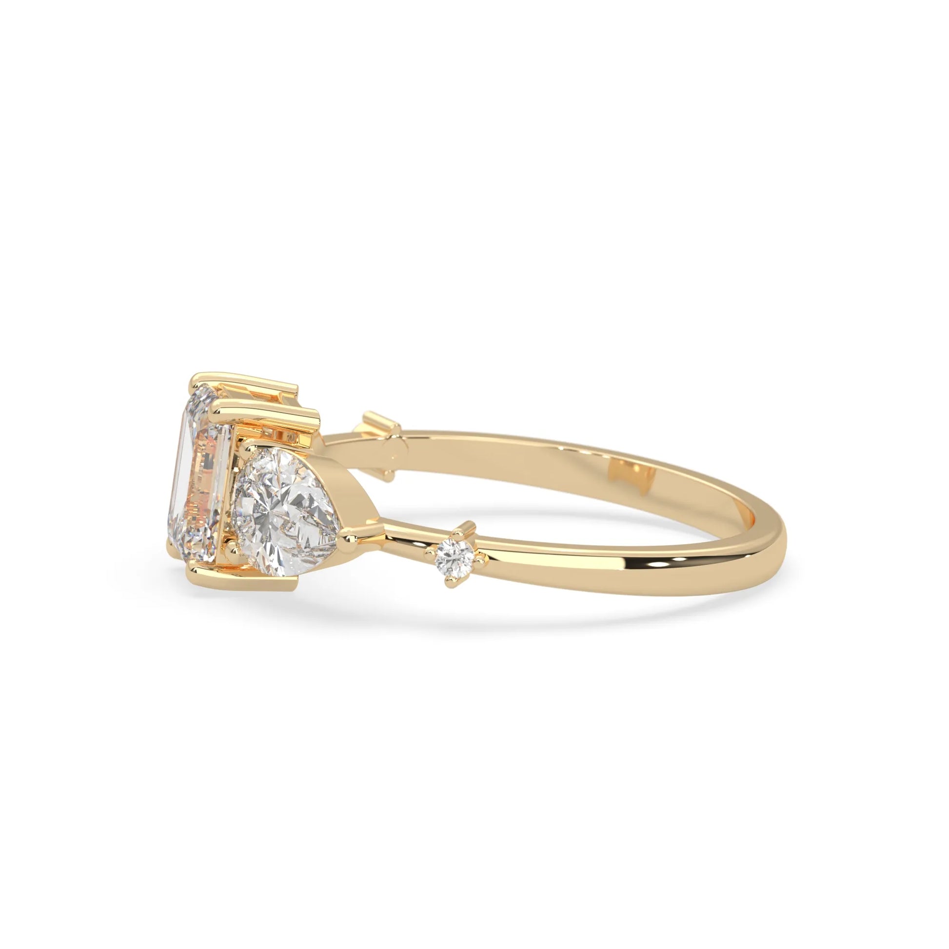 Emerald cut lab grown diamond engagement ring with pear and round diamond three stone design in yellow gold