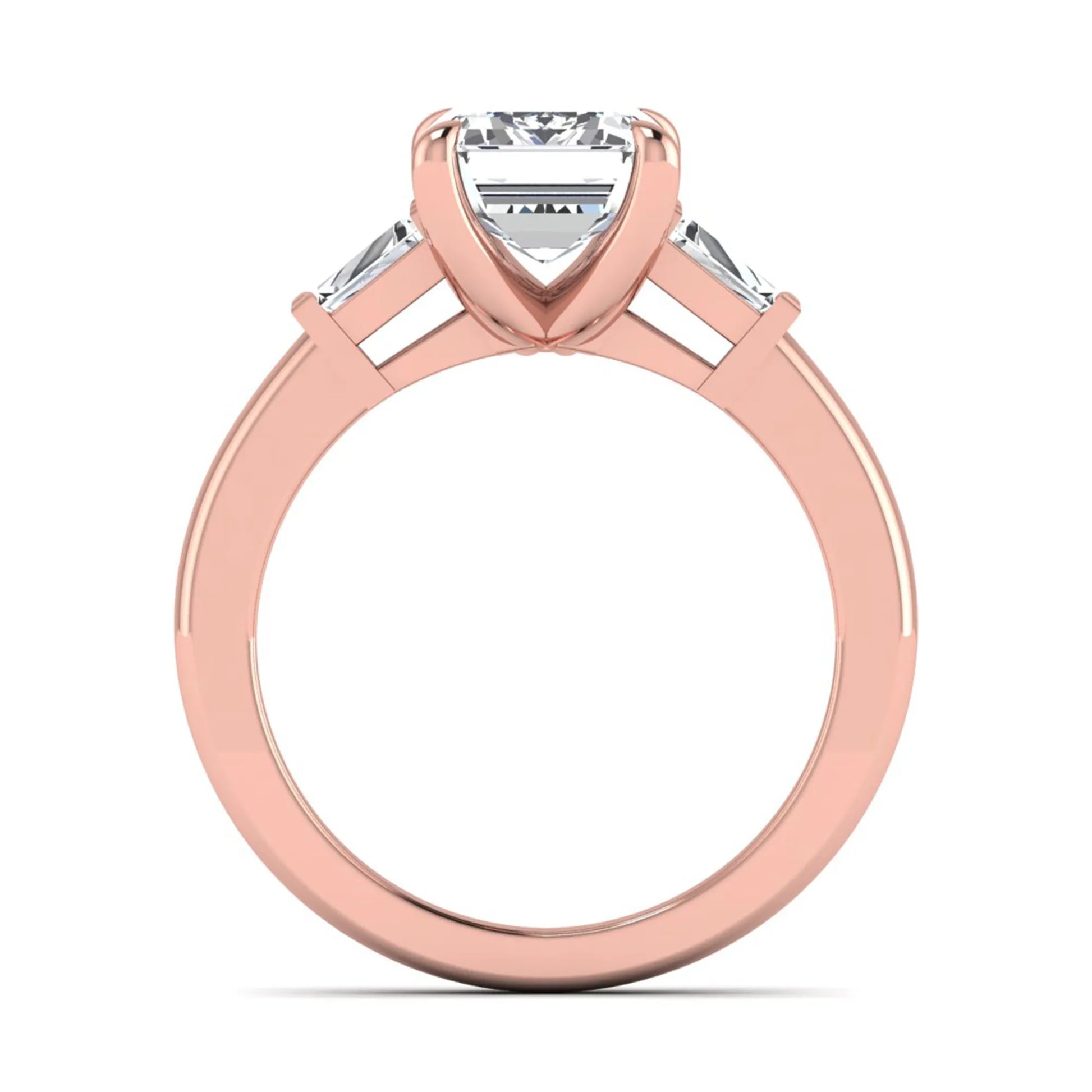 Emerald cut lab grown diamond three-stone engagement ring featuring tapered baguette side diamonds in a classic four-prong rose gold style setting.