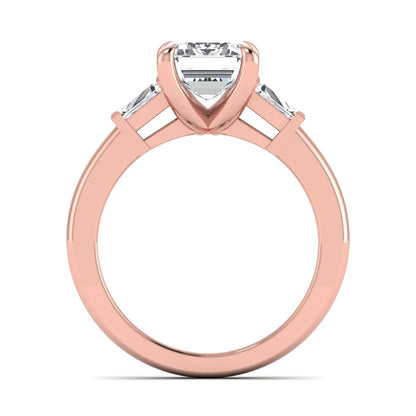 Emerald cut lab grown diamond three-stone engagement ring featuring tapered baguette side diamonds in a classic four-prong rose gold style setting.