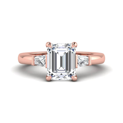 Emerald cut lab grown diamond three-stone engagement ring featuring tapered baguette side diamonds in a classic four-prong rose gold style setting.