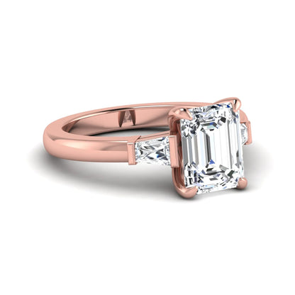 Emerald cut lab grown diamond three-stone engagement ring featuring tapered baguette side diamonds in a classic four-prong rose gold style setting.