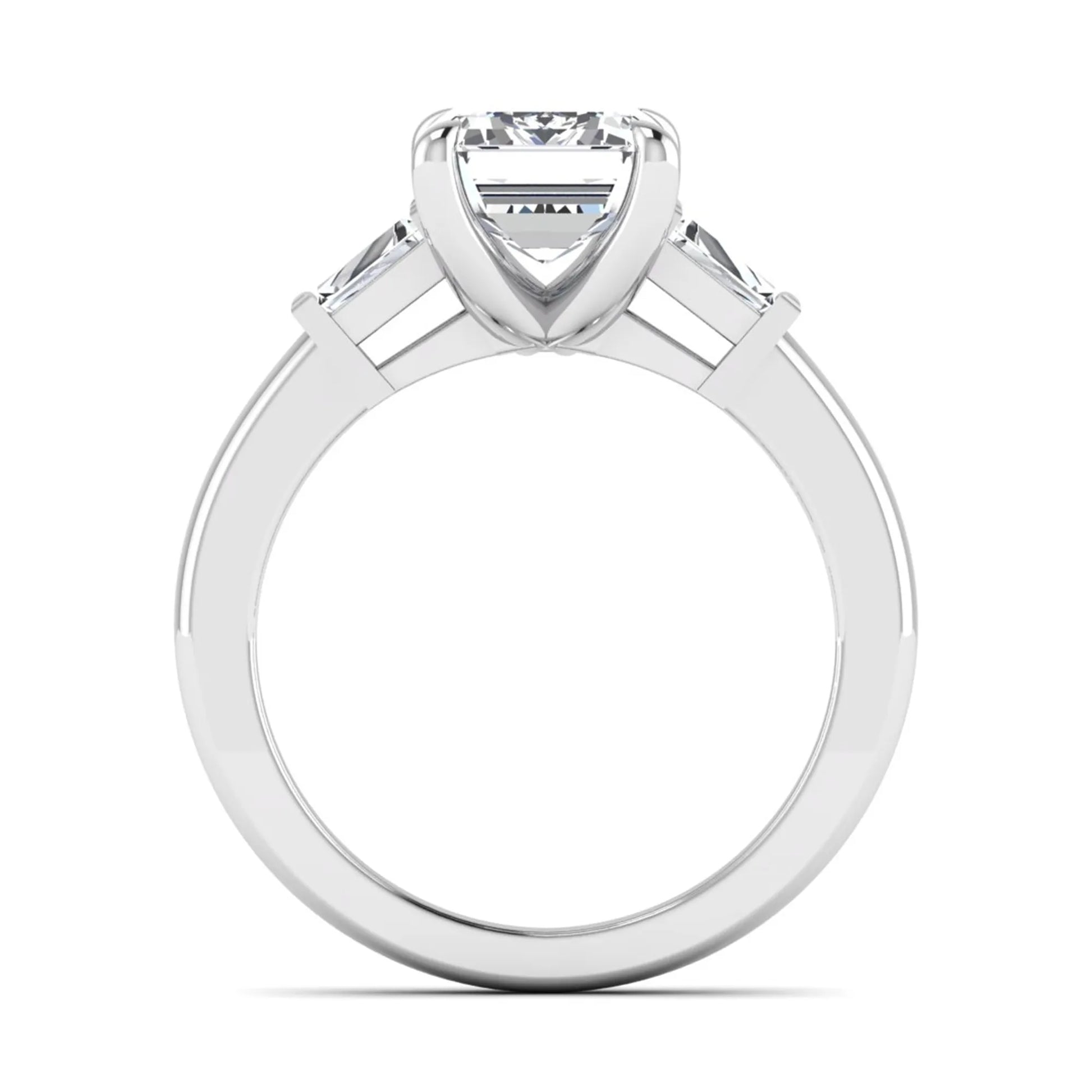 Emerald cut lab grown diamond three-stone engagement ring featuring tapered baguette side diamonds in a classic four-prong white gold style setting.