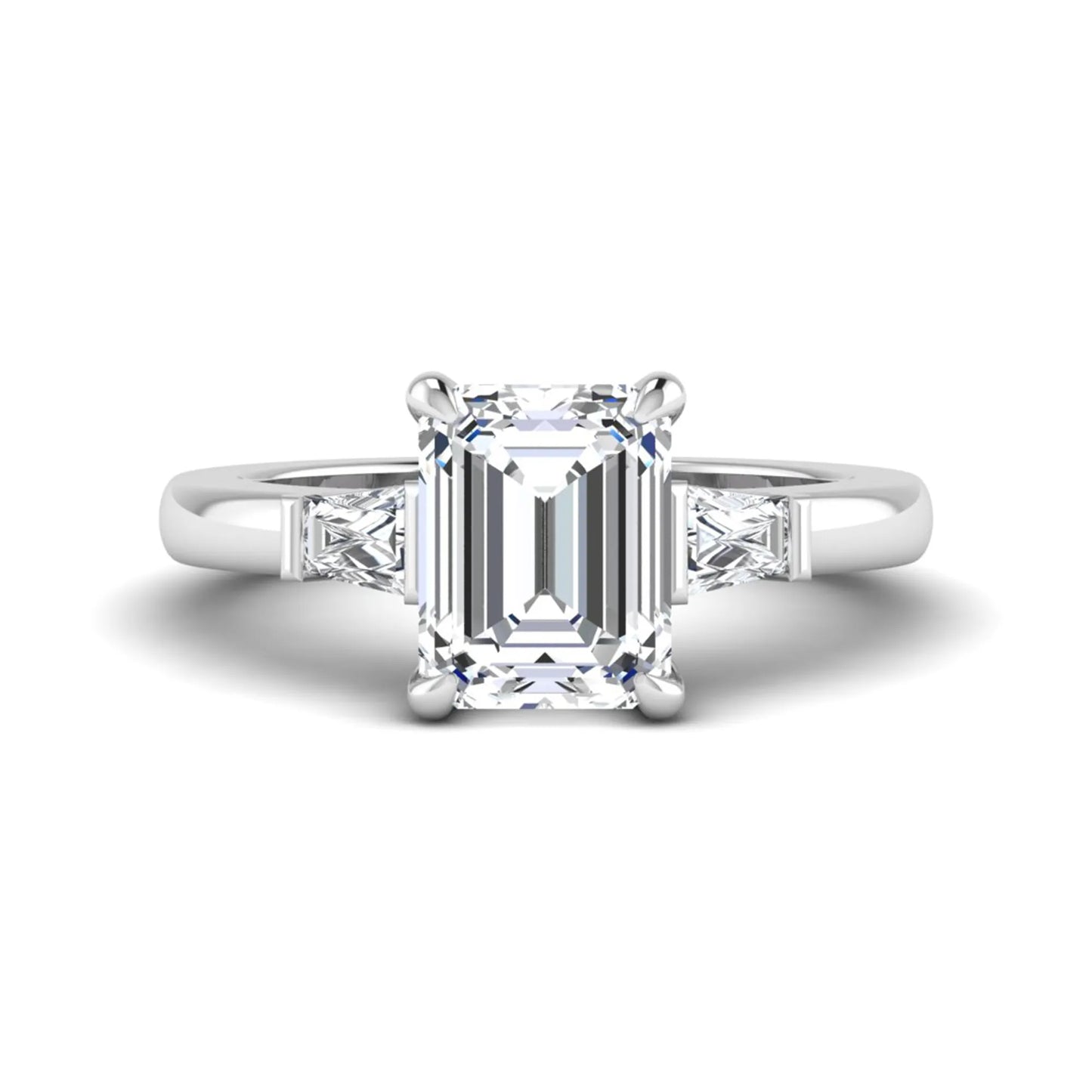 Emerald cut lab grown diamond three-stone engagement ring featuring tapered baguette side diamonds in a classic four-prong white gold style setting.
