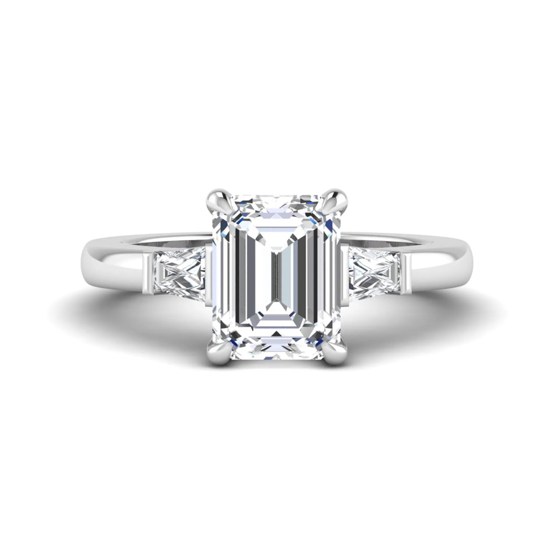 Emerald cut lab grown diamond three-stone engagement ring featuring tapered baguette side diamonds in a classic four-prong white gold style setting.