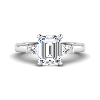 Emerald cut lab grown diamond three-stone engagement ring featuring tapered baguette side diamonds in a classic four-prong white gold style setting.