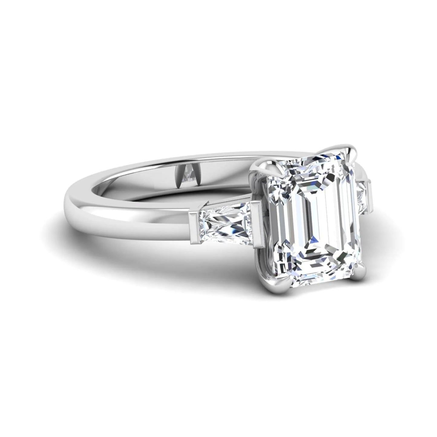 Emerald cut lab grown diamond three-stone engagement ring featuring tapered baguette side diamonds in a classic four-prong white gold style setting.