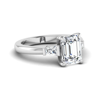 Emerald cut lab grown diamond three-stone engagement ring featuring tapered baguette side diamonds in a classic four-prong white gold style setting.