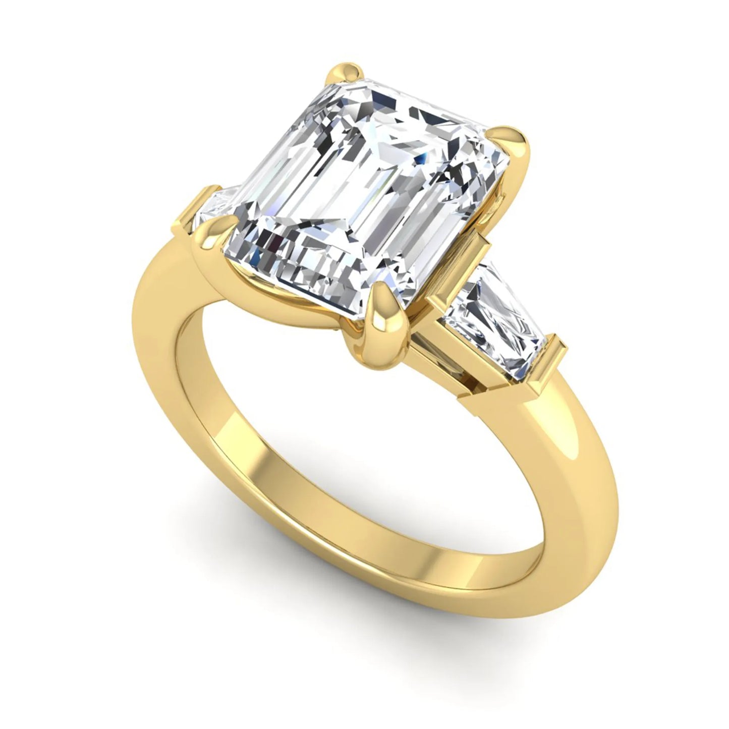 Emerald cut lab grown diamond three-stone engagement ring featuring tapered baguette side diamonds in a classic four-prong yellow gold style setting.