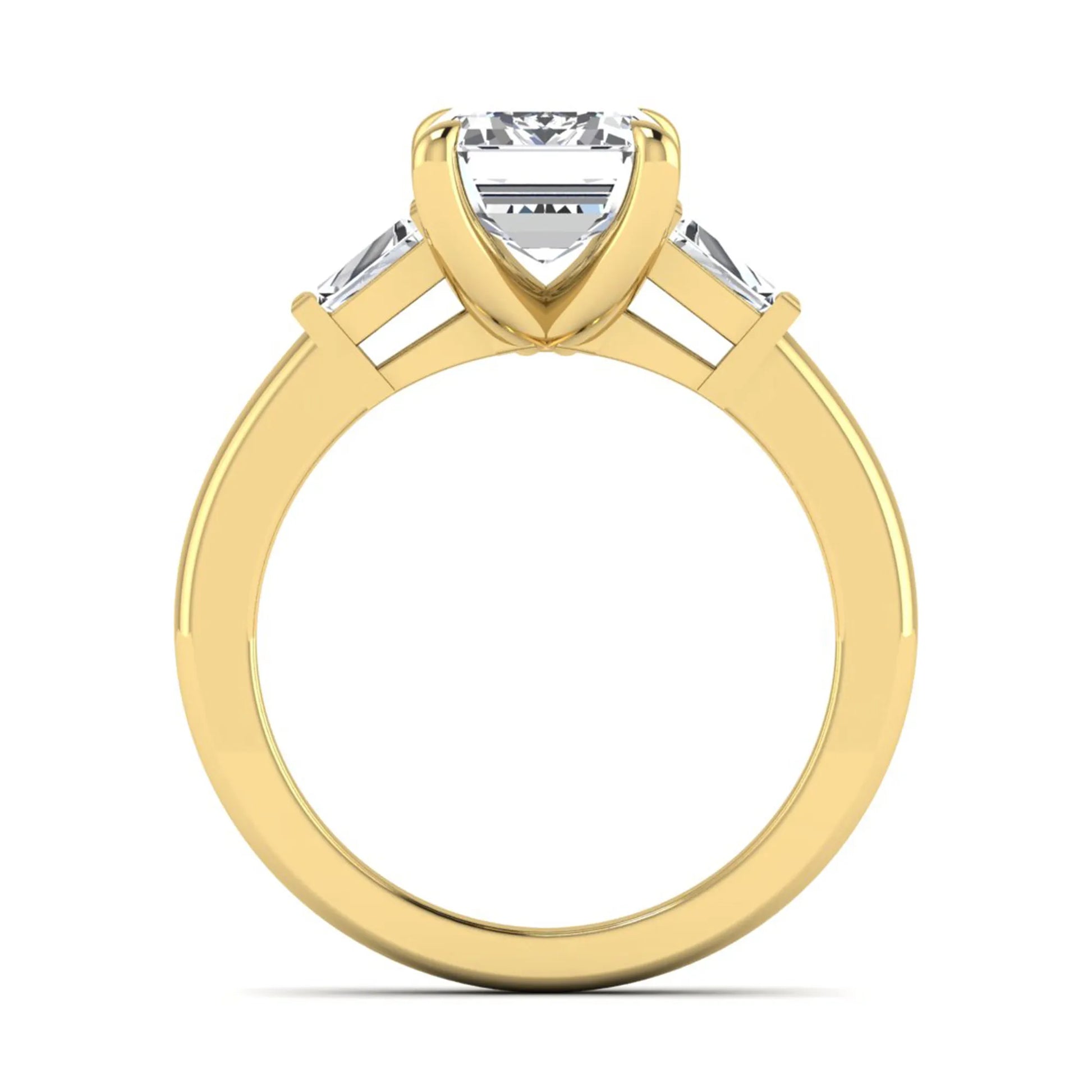 Emerald cut lab grown diamond three-stone engagement ring featuring tapered baguette side diamonds in a classic four-prong yellow gold style setting.