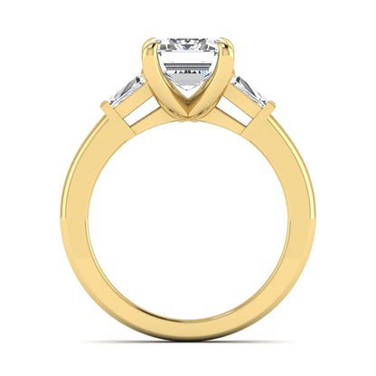 Emerald cut lab grown diamond three-stone engagement ring featuring tapered baguette side diamonds in a classic four-prong yellow gold style setting.