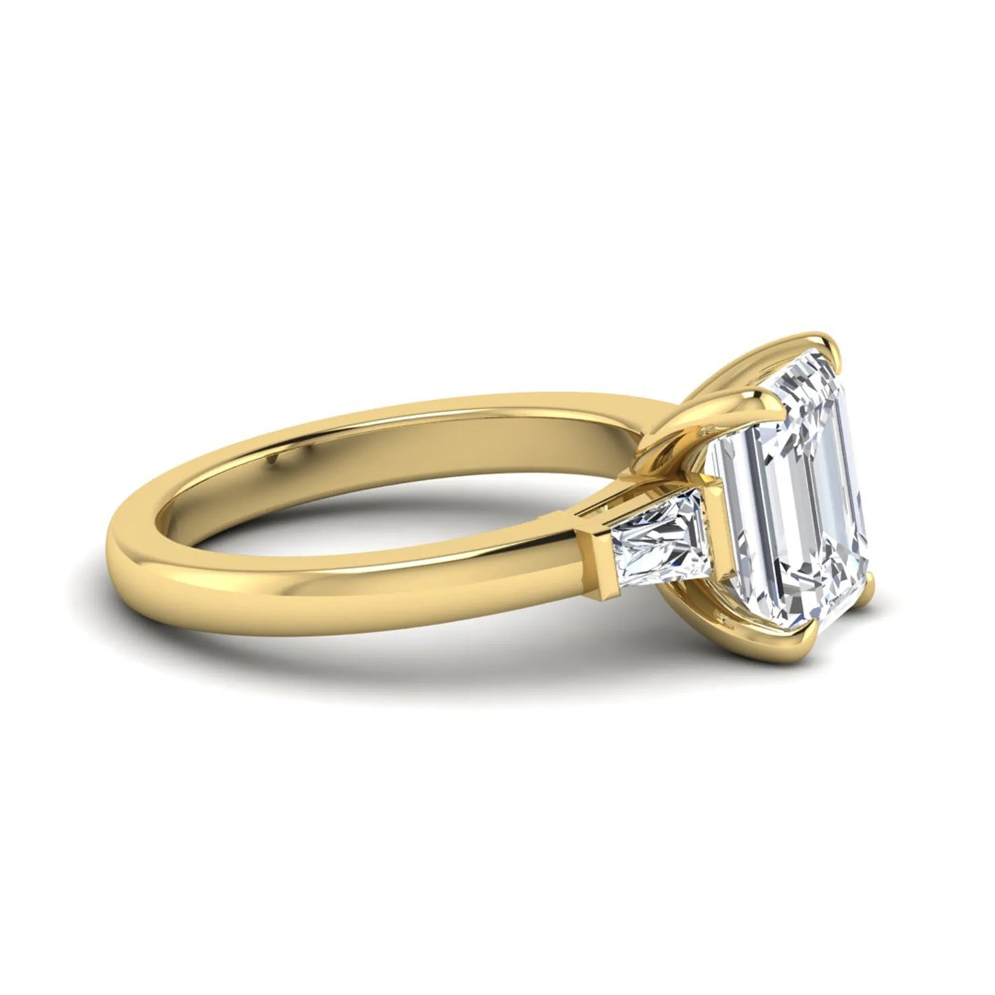 Emerald cut lab grown diamond three-stone engagement ring featuring tapered baguette side diamonds in a classic four-prong yellow gold style setting.