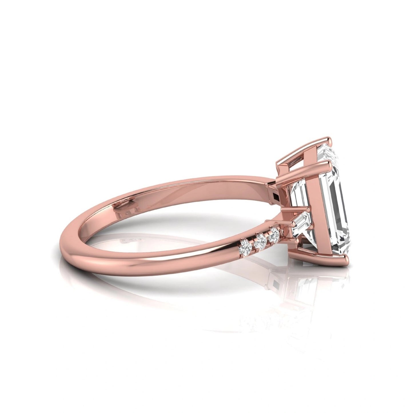 Emerald cut lab grown diamond engagement ring featuring an IGI certified center diamond with baguette and round side diamonds in a classic four-prong three-stone setting in rose gold