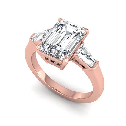 Emerald three stone prong set lab grown diamond engagement ring featuring a 3.00 carat emerald cut center diamond with tapered baguette side diamonds in rose gold finish.