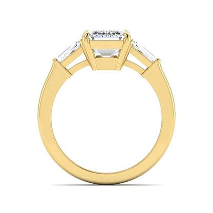 Emerald three stone prong set lab grown diamond engagement ring featuring a 3.00 carat emerald cut center diamond with tapered baguette side diamonds in yellow gold finish.