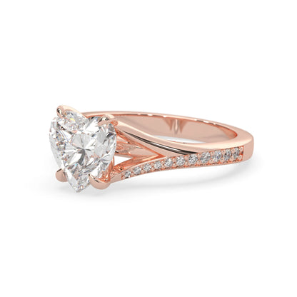 Rose gold ring with a large heart-shaped lab grown diamond and smaller diamonds on the band against a white background