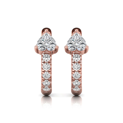 Heart cut lab grown diamond huggie hoop earrings featuring a three prong basket set center diamond with round brilliant pavé diamonds on a rose gold hoop.