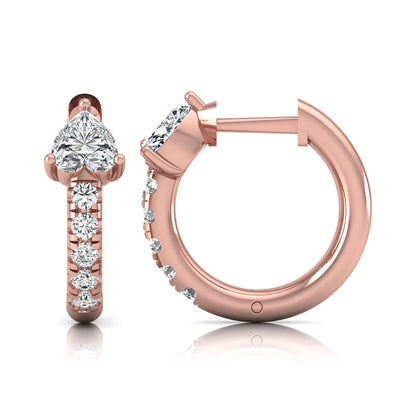 Heart cut lab grown diamond huggie hoop earrings featuring a three prong basket set center diamond with round brilliant pavé diamonds on a rose gold hoop.