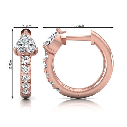 Heart cut lab grown diamond huggie hoop earrings featuring a three prong basket set center diamond with round brilliant pavé diamonds on a rose gold hoop.