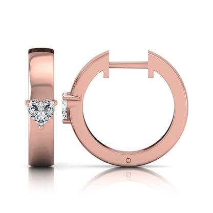 Heart cut lab grown diamond huggie hoop earrings featuring a classic four prong setting and hinged snap closure shown in rose gold tone with a polished finish.