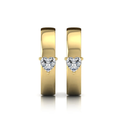 Heart cut lab grown diamond huggie hoop earrings featuring a classic four prong setting and hinged snap closure shown in yellow gold tone with a polished finish.