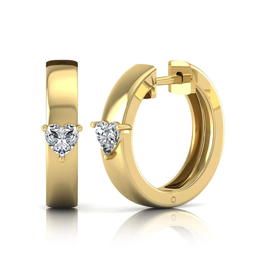 Heart cut lab grown diamond huggie hoop earrings featuring a classic four prong setting and hinged snap closure shown in yellow gold tone with a polished finish.