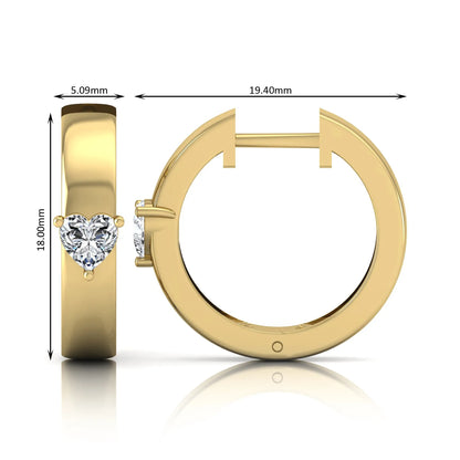 Heart cut lab grown diamond huggie hoop earrings featuring a classic four prong setting and hinged snap closure shown in yellow gold tone with a polished finish.