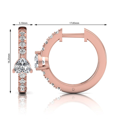 Heart and round cut lab grown diamond pavé huggie hoop earrings featuring a front-facing heart diamond, graduated shared prong round diamonds, hinged snap closure, and polished rose gold finish.