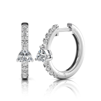 Heart and round cut lab grown diamond pavé huggie hoop earrings featuring a front-facing heart diamond, graduated shared prong round diamonds, hinged snap closure, and polished white gold finish.