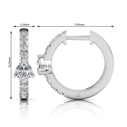 Heart and round cut lab grown diamond pavé huggie hoop earrings featuring a front-facing heart diamond, graduated shared prong round diamonds, hinged snap closure, and polished white gold finish.