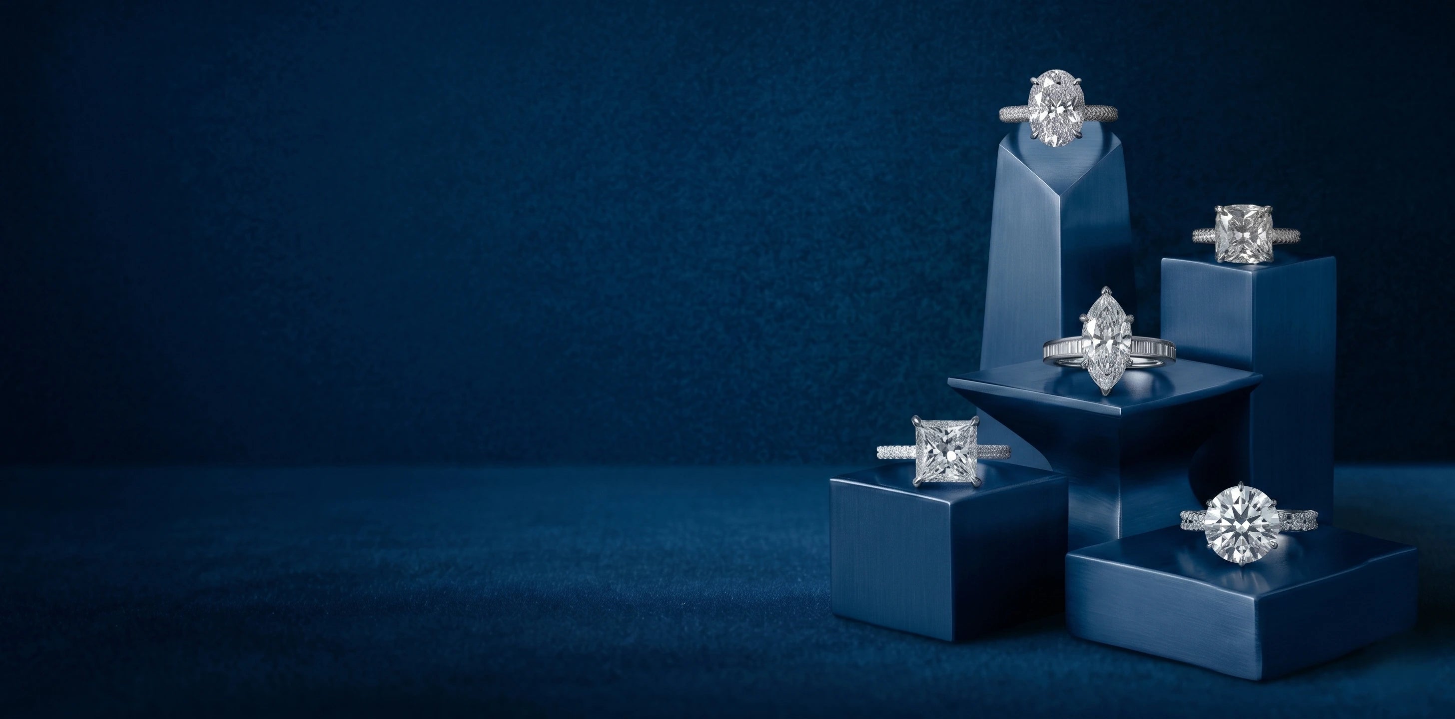 Diamond rings on blue stands against a dark blue background
