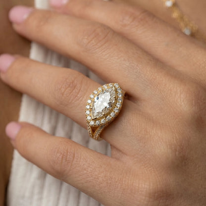 yellow-gold Close-up of a hand wearing a gold ring with a large diamond on a blurred background