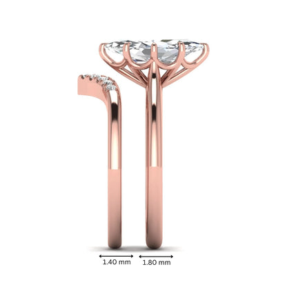 Marquise cut lab grown diamond bypass engagement ring with round side diamonds in a prong setting and rose gold tone band.