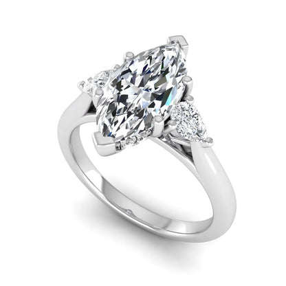 Marquise cut lab grown diamond three stone engagement ring with prong setting, round and pear side diamonds, white gold tone shown for design reference.