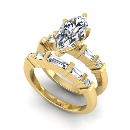 Marquise cut lab grown diamond bridal ring set featuring a six-prong solitaire engagement ring with a contour wedding band accented by baguette and round diamonds in a yellow gold finish.
