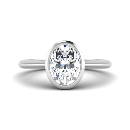 Oval cut lab grown diamond solitaire engagement ring in a bezel setting with a white gold tone minimalist band.
