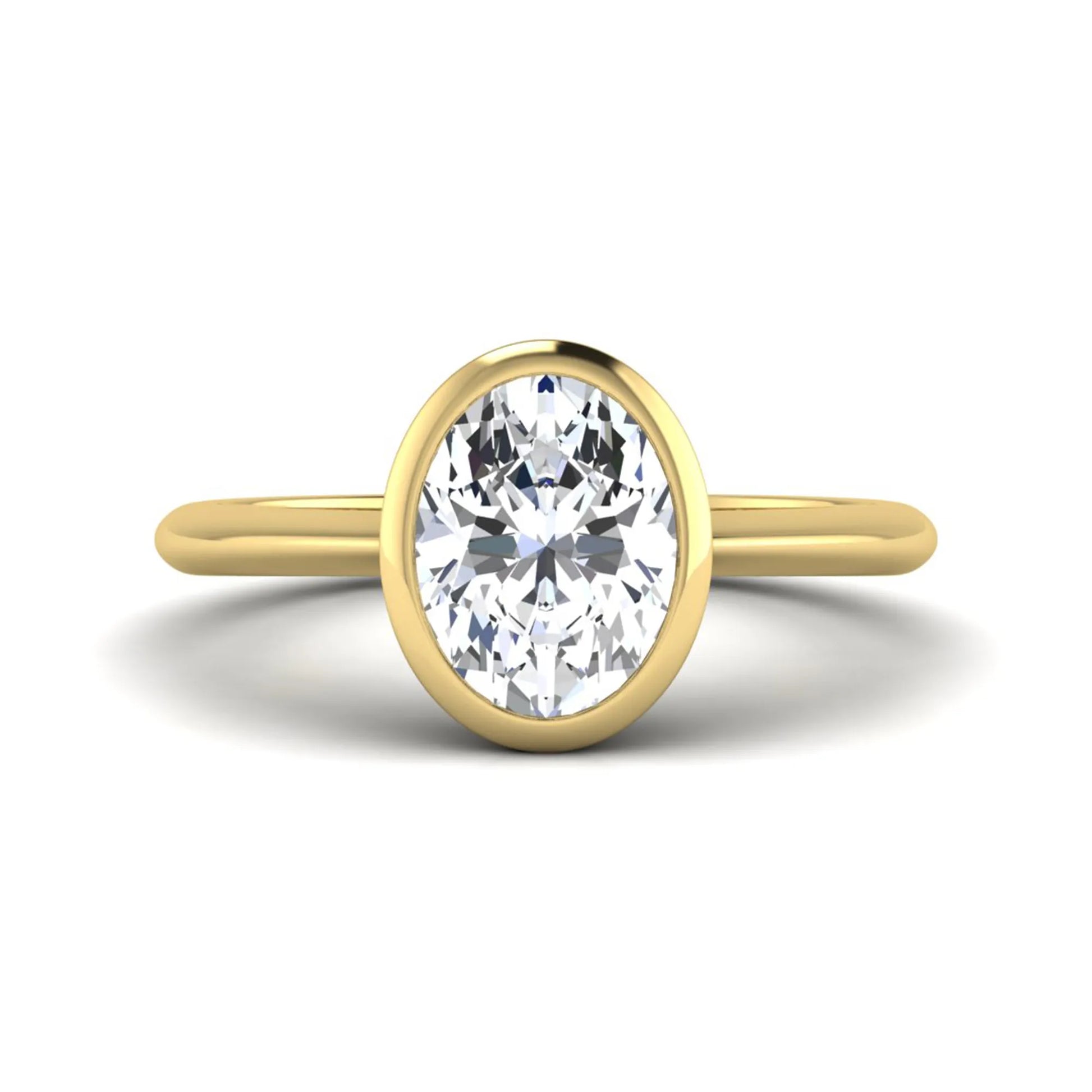 Oval cut lab grown diamond solitaire engagement ring in a bezel setting with a yellow gold tone minimalist band.
