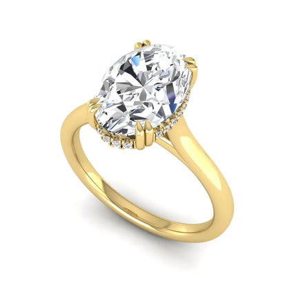 Oval cut hidden halo lab grown diamond engagement ring with double claw prongs in yellow gold.