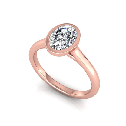 Oval cut lab grown diamond bezel solitaire engagement ring featuring a 0.75 carat center diamond in polished rose gold.