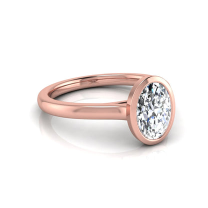 Oval cut lab grown diamond bezel solitaire engagement ring featuring a 0.75 carat center diamond in polished rose gold.