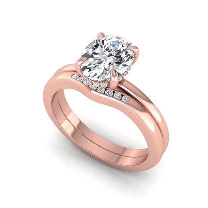 IGI certified oval cut lab grown diamond bridal ring set featuring a hidden halo engagement ring with a matching curved diamond wedding band in rose gold.