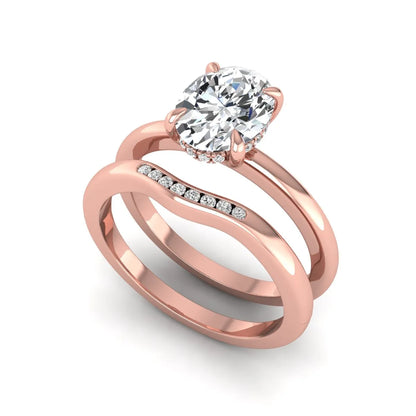 IGI certified oval cut lab grown diamond bridal ring set featuring a hidden halo engagement ring with a matching curved diamond wedding band in rose gold.